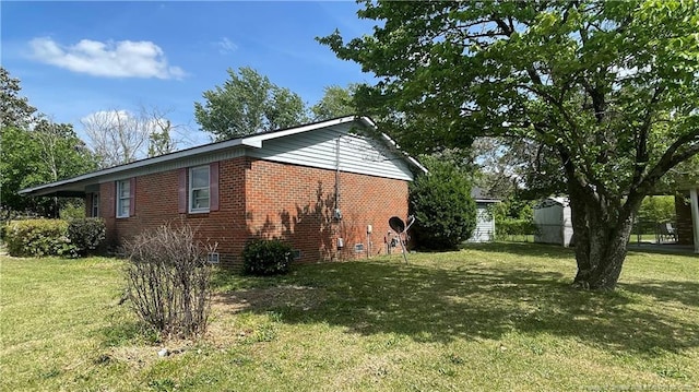 view of side of home featuring brick siding, a yard, and crawl space