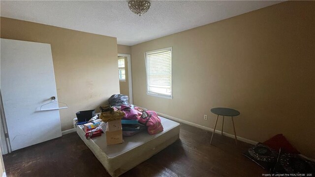 bedroom with baseboards and a textured ceiling