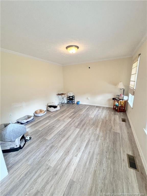 miscellaneous room with light hardwood / wood-style flooring and crown molding