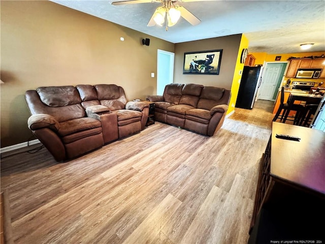 living room with light hardwood / wood-style floors and ceiling fan