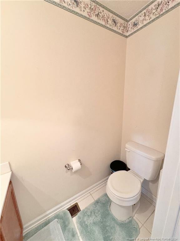 bathroom featuring tile patterned flooring, vanity, and toilet