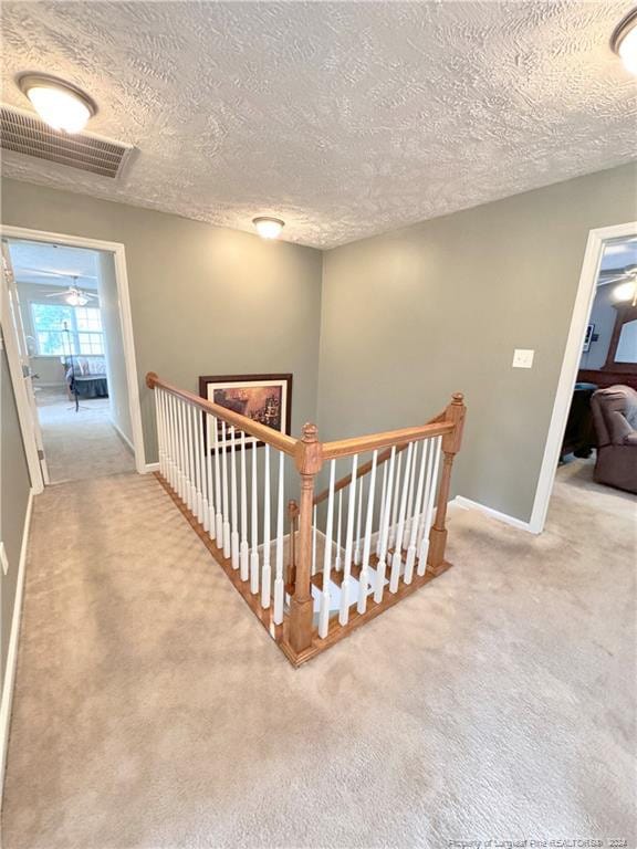 hallway with carpet and a textured ceiling