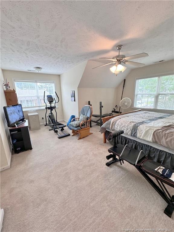 carpeted bedroom featuring multiple windows, a textured ceiling, and ceiling fan