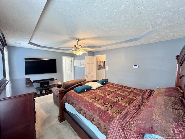 bedroom featuring light carpet, a textured ceiling, and ceiling fan