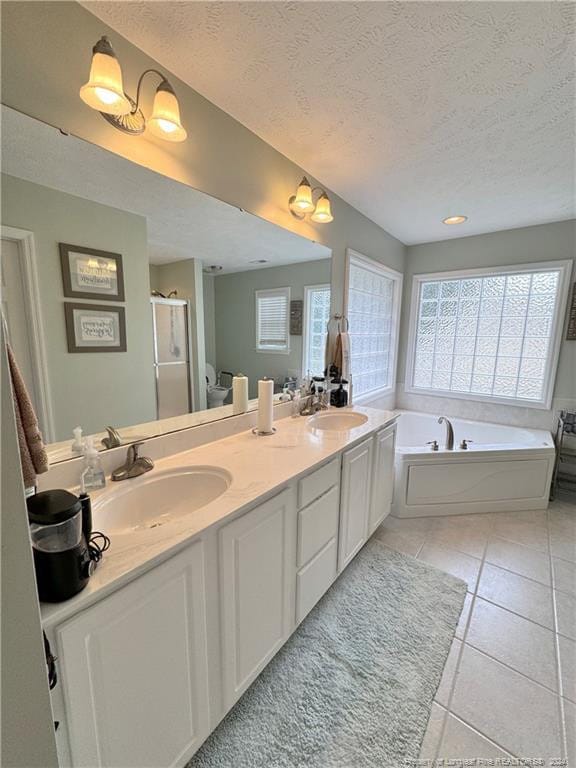 bathroom featuring vanity, independent shower and bath, tile patterned flooring, and a textured ceiling