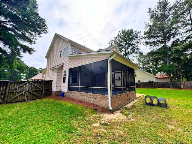 back of house featuring ceiling fan, a sunroom, and a yard