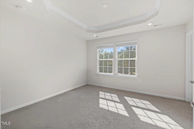 unfurnished room featuring ornamental molding, a raised ceiling, and light colored carpet