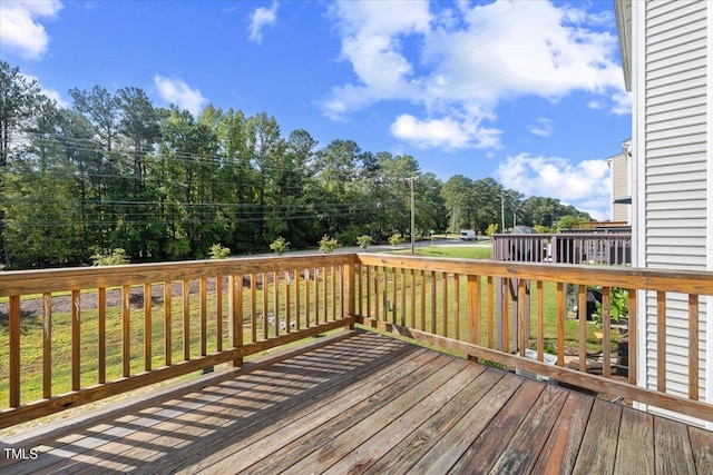 wooden terrace featuring a lawn