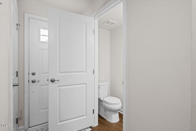 bathroom with hardwood / wood-style floors and toilet