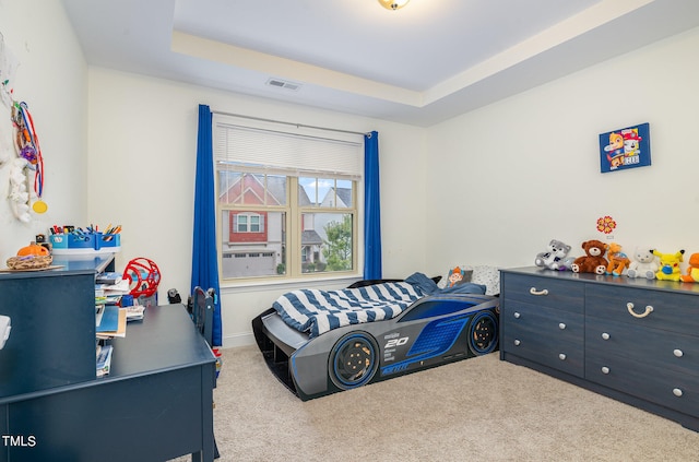 carpeted bedroom with a raised ceiling