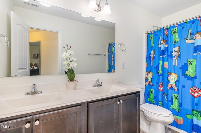 bathroom featuring vanity, toilet, and curtained shower