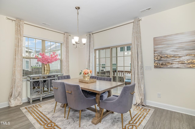 dining area with an inviting chandelier and hardwood / wood-style floors