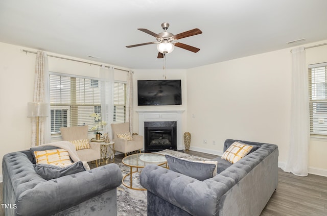 living room with ceiling fan, hardwood / wood-style flooring, and a fireplace