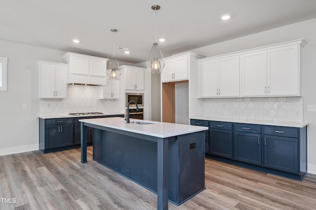 kitchen featuring sink, white cabinets, decorative light fixtures, and blue cabinets