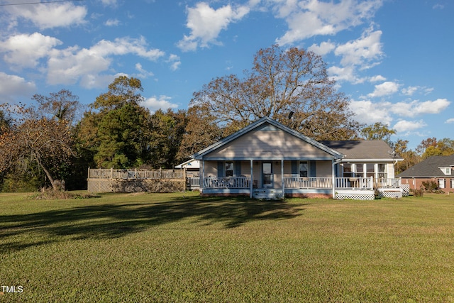 rear view of house featuring a yard and covered porch