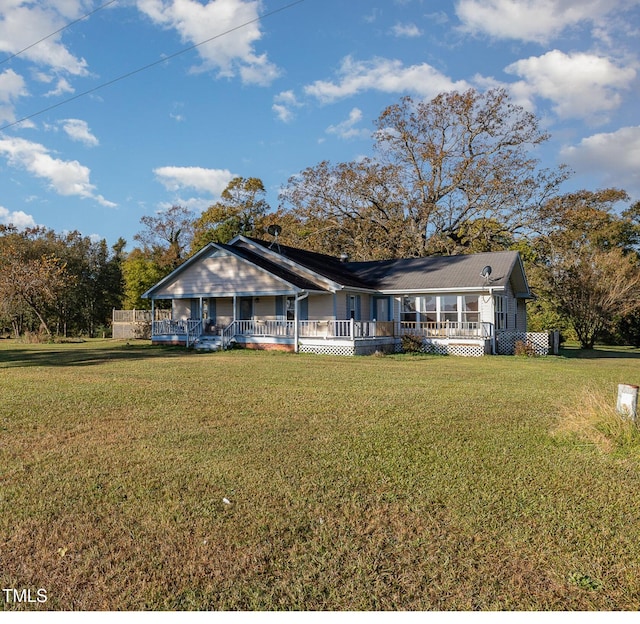 back of house featuring a lawn and covered porch