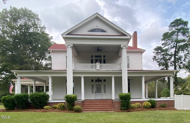 greek revival inspired property featuring a front yard, ceiling fan, and covered porch