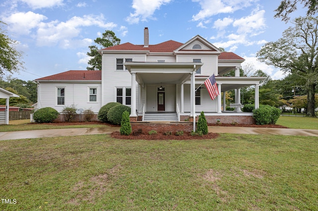 view of front facade featuring a front yard and covered porch