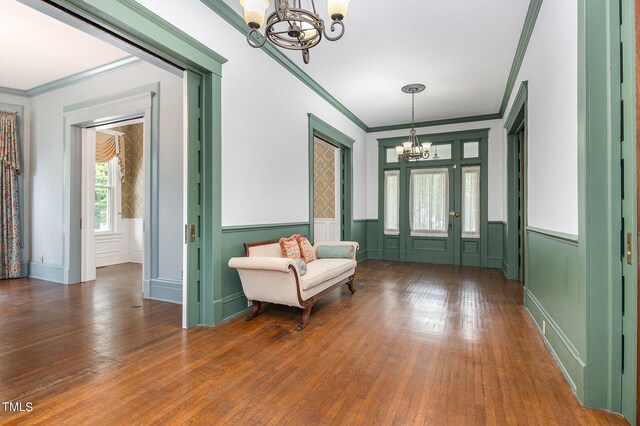 interior space with ornamental molding, dark hardwood / wood-style flooring, and a chandelier