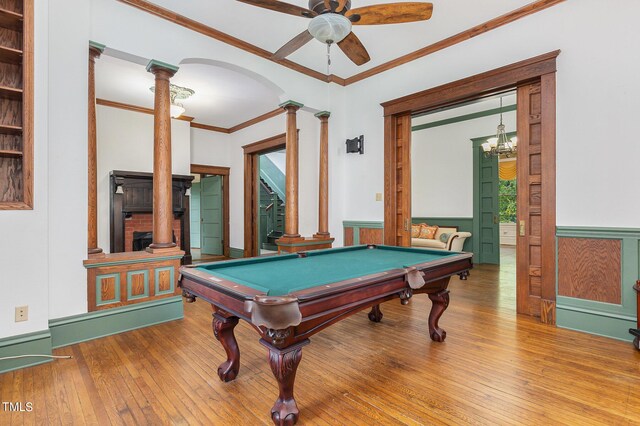 playroom featuring wood-type flooring, ceiling fan with notable chandelier, decorative columns, billiards, and crown molding