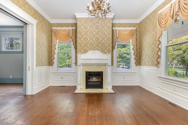 unfurnished living room with plenty of natural light, dark hardwood / wood-style floors, and crown molding