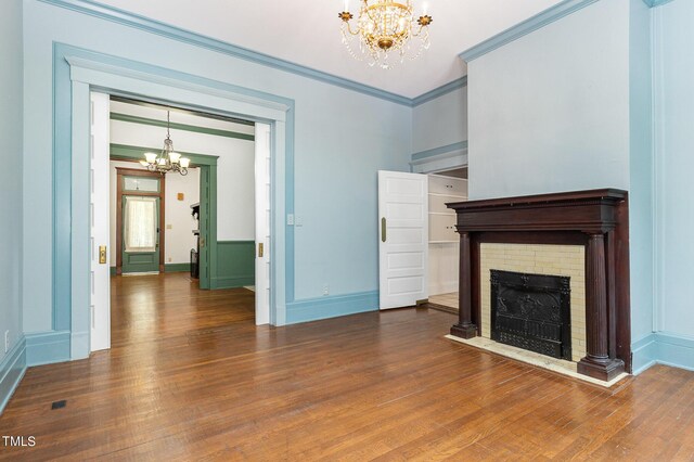 unfurnished living room with crown molding, dark hardwood / wood-style flooring, and a chandelier