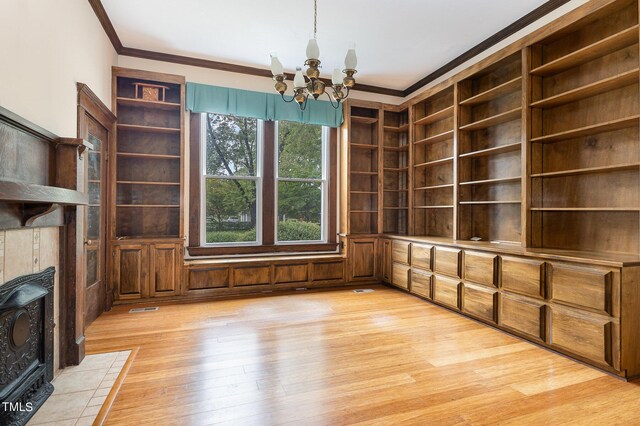 interior space featuring light wood-type flooring, ornamental molding, and a chandelier