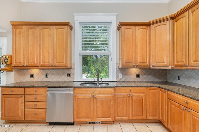 kitchen featuring light tile patterned floors, sink, dishwasher, dark stone counters, and decorative backsplash