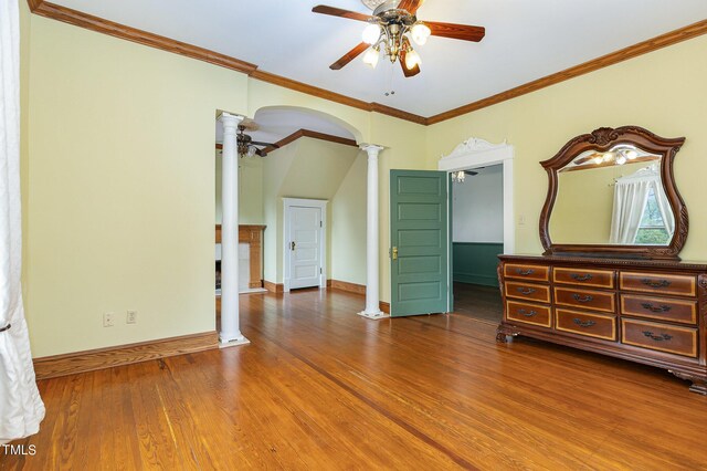 unfurnished bedroom with ceiling fan, hardwood / wood-style flooring, crown molding, and ornate columns