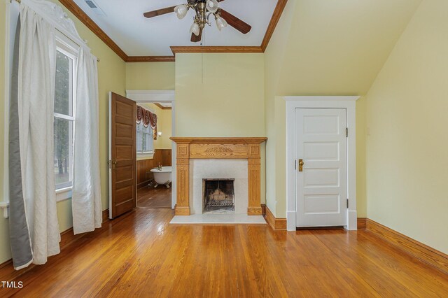 unfurnished living room with ceiling fan, a fireplace, ornamental molding, and wood-type flooring