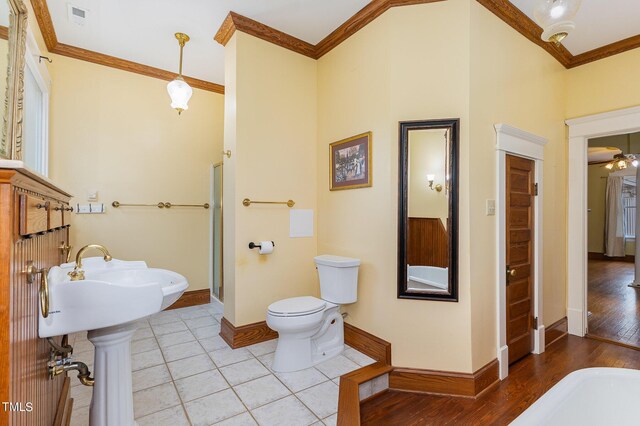 bathroom featuring crown molding, walk in shower, hardwood / wood-style floors, and toilet