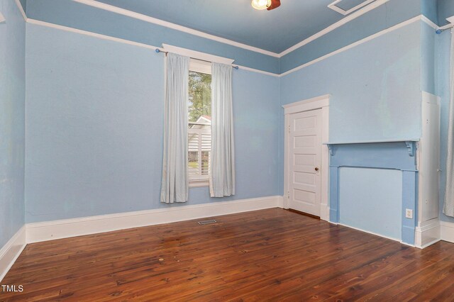 spare room featuring dark hardwood / wood-style floors and crown molding