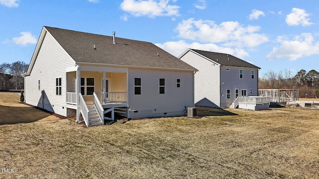 rear view of house with a deck, cooling unit, and a yard