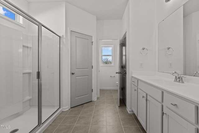 bathroom featuring toilet, tile patterned floors, walk in shower, and vanity