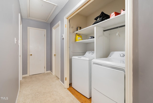 clothes washing area featuring light hardwood / wood-style floors and washer and dryer