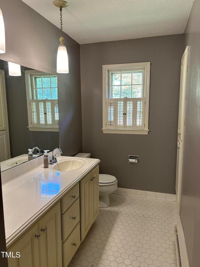 bathroom with vanity, a textured ceiling, a baseboard radiator, toilet, and tile patterned floors