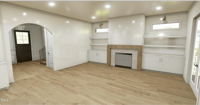 unfurnished living room with light hardwood / wood-style flooring, built in shelves, a fireplace, and ornamental molding