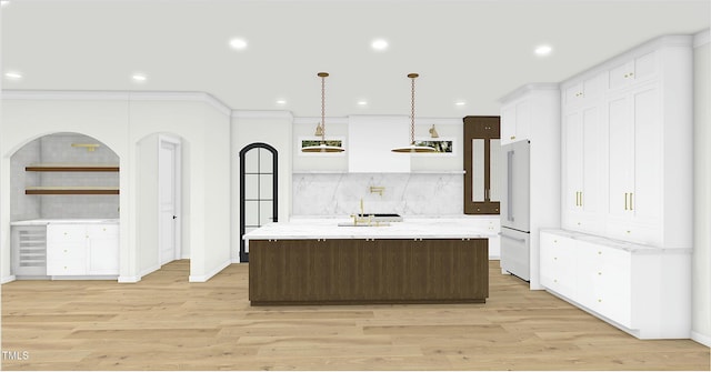 kitchen with pendant lighting, white fridge, light stone countertops, a center island with sink, and light wood-type flooring