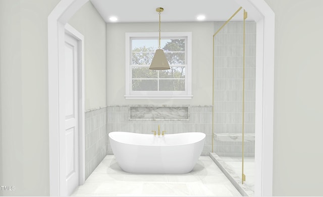 bathroom featuring a washtub and tile walls