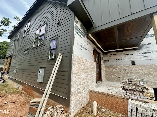 view of side of property featuring brick siding and board and batten siding