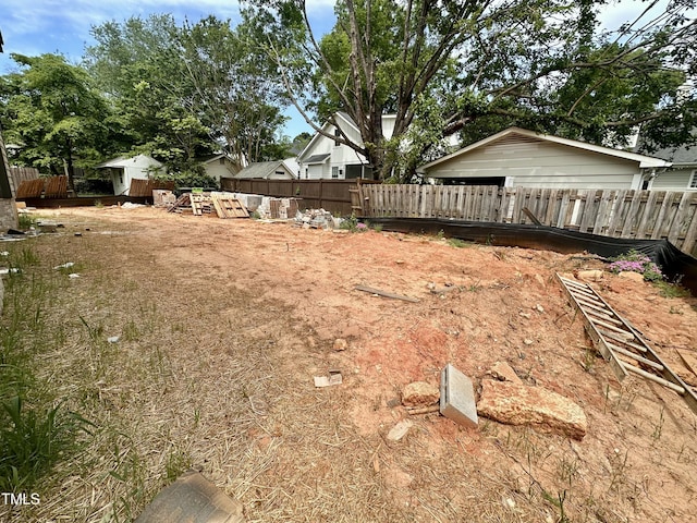 view of yard featuring an outbuilding, a fenced backyard, and a storage unit