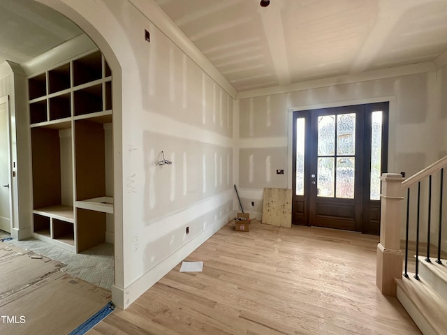 mudroom featuring wood finished floors and arched walkways
