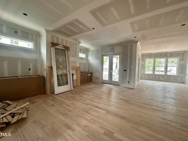 unfurnished living room with light wood-style flooring, french doors, and elevator
