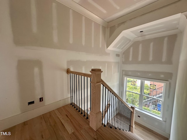 stairway with wood finished floors and baseboards