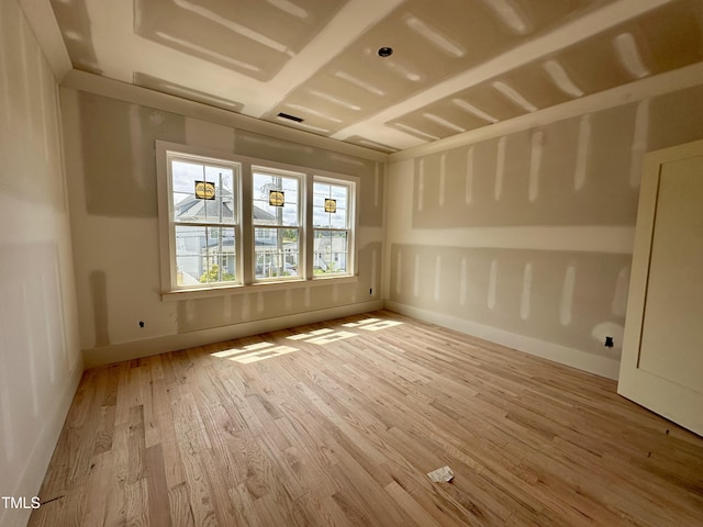 unfurnished room with baseboards and wood finished floors