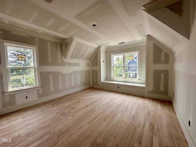 additional living space featuring lofted ceiling, light wood-style flooring, and baseboards