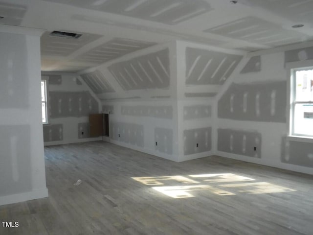 additional living space featuring lofted ceiling and wood-type flooring