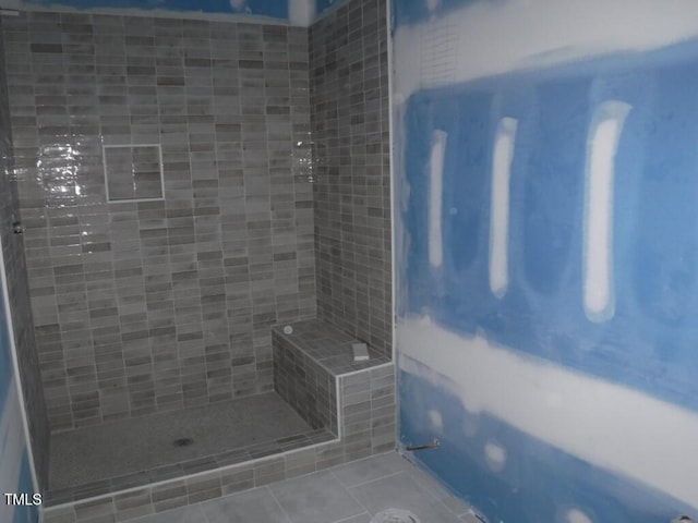 bathroom with tile patterned flooring and tiled shower