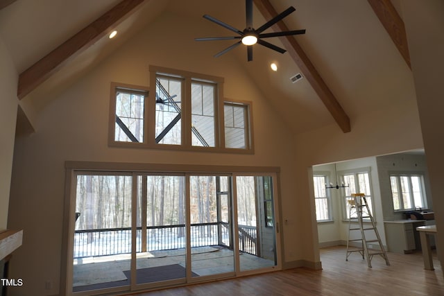 living room featuring baseboards, visible vents, beamed ceiling, wood finished floors, and high vaulted ceiling