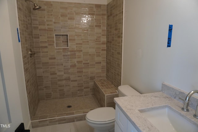 full bath with toilet, a tile shower, and vanity